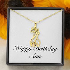 a giraffe necklace with the words happy birthday written on it in gold plating