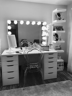 a black and white photo of a desk with a mirror, lights, and chair