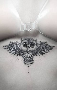 an owl tattoo on the back of a woman