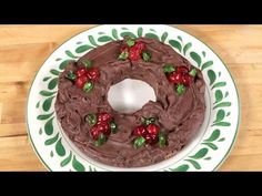 a cake with chocolate frosting and cherries on a green and white platter