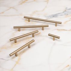 five brass handles on a marble surface