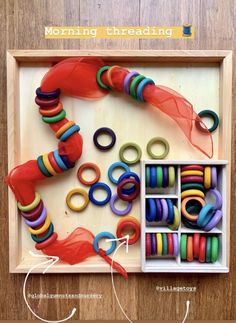 an assortment of colorful beads and rings in a wooden box