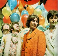 the beatles are standing in front of balloons