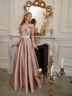 a woman standing in front of a mirror wearing a pink dress