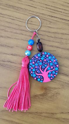 a keychain with a tree on it sitting on top of a wooden table