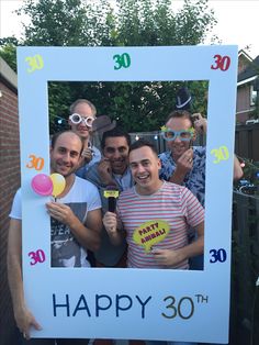 a group of men standing next to each other in front of a happy 30th sign