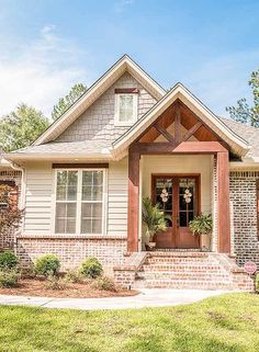 a house that is in the middle of some grass and flowers on the front porch