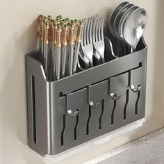 a metal utensil holder holds silverware and spoons