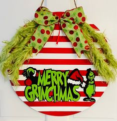 a christmas wreath hanging on a door with green and red stripes, decorated with the words merry grinmas