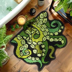 a green and black rug on the floor next to a potted plant with candles