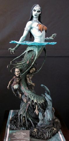 a statue of a mermaid sitting on top of a table