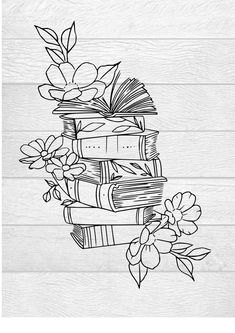 a stack of books with flowers and leaves on it, next to a wooden wall