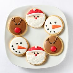 four decorated christmas cookies on a white plate