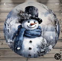 a snowman with a hat and scarf on it's head is shown in front of a wooden background