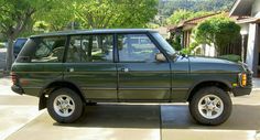 a green suv parked in front of a house