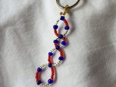 a red, white and blue beaded keychain is hanging from a metal ring