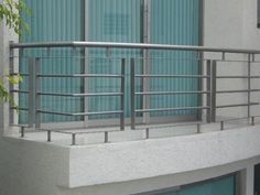 a balcony with metal railings next to a building