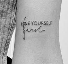 a woman's arm with the words love yourself first tattooed on her left side