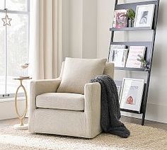 a living room with a chair, bookshelf and pictures on the wall