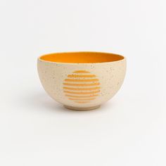 an orange and white bowl on a white background