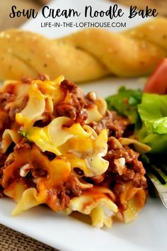 a white plate topped with pasta and meat