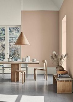 a dining room with an open floor plan and large windows in the back ground area