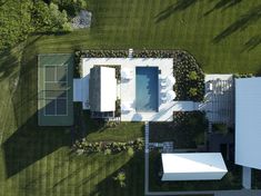 an aerial view of a house with a pool and tennis court