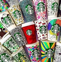 many starbucks cups are lined up together on the table with different patterns and designs painted on them