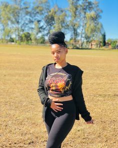 a woman standing in the middle of a field wearing leggings and a crop top