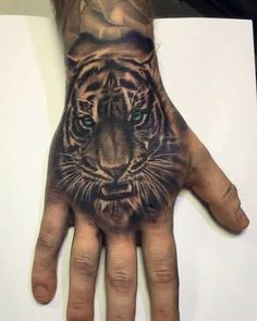 a hand with a tiger tattoo on it's palm and the eyes are blue