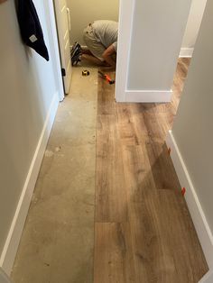 a man laying on the floor in front of an open door