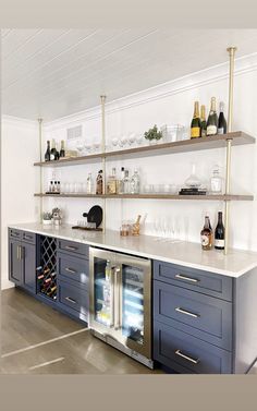 a kitchen with open shelving and wine bottles on the shelves