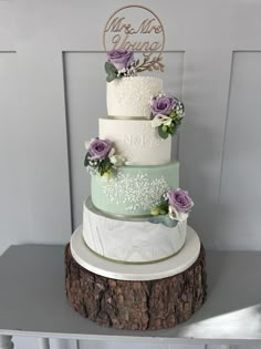 a three tiered wedding cake with purple flowers