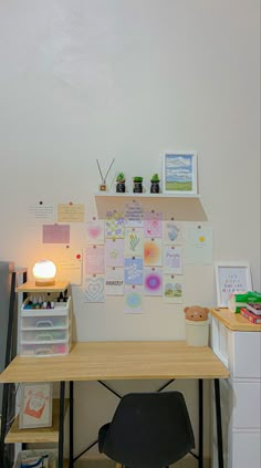 a desk with a chair, lamp and pictures on the wall