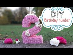 the number two is made out of pink sprinkles and flowers on the ground