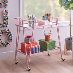 a pink cart with lots of colorful items on it