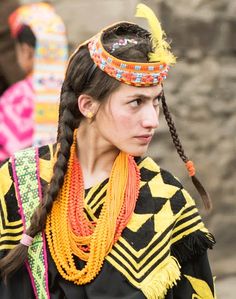 a woman with long braids wearing an elaborate headdress