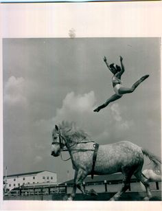 a woman riding on the back of a horse while flying through the air above it