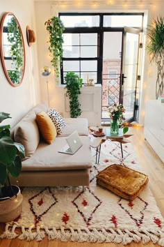 a living room filled with furniture and lots of plants on top of the rugs