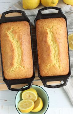 two loafs of lemon pound cake on a cooling rack next to some sliced lemons