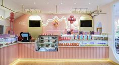 the inside of a bakery with pink walls