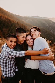 3 teenage boys snuggle up against their mom in front of a mountain valley backdrop. Teenage Family Photos Sibling Poses, 4 Older Siblings Picture Ideas, Teenage Family Christmas Photos, Teenage Family Photoshoot Ideas, Mom And Sons Photo Ideas Older, Teenage Family Photography, Older Family Photography Poses, Creative Family Poses, Posing Family Of 4 With Teens