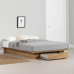 a bed sitting on top of a wooden platform next to a white wall and floor