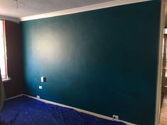 an empty room with blue paint on the walls