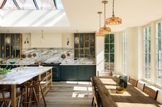 a kitchen with marble counter tops and wooden chairs in front of an open floor plan