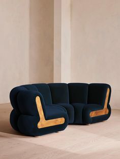 a blue couch sitting on top of a hard wood floor next to a white wall