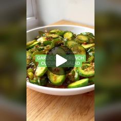 a white bowl filled with green vegetables on top of a wooden table