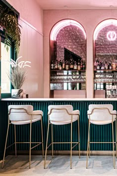 three bar stools are lined up in front of the bar