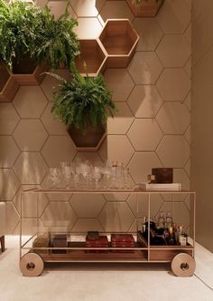 a bar cart with drinks on it in front of a wall decorated with hexagonal tiles