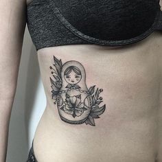 a woman's stomach with a small tattoo on her belly and an angel in the center